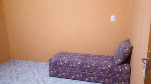 a purple couch in a corner of a room at Rancho do Carlinhos in Ipoema