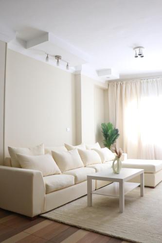 a white living room with a white couch and a table at Queen Nefertari in Cairo