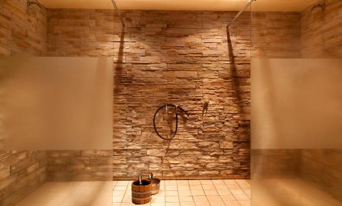 uma casa de banho com uma parede de pedra e uma banheira em Hotel Ahornhof em Lindberg