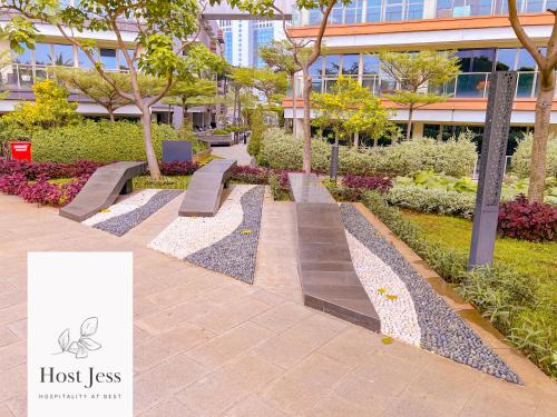 a park with benches in front of a building at Gold Coast PIK Apartments by Host Jess in Jakarta