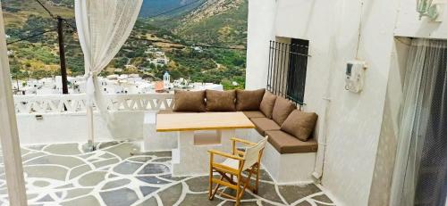 - un balcon avec un canapé, une table et des chaises dans l'établissement Vasiliki Skyros Castle View, à Skiros