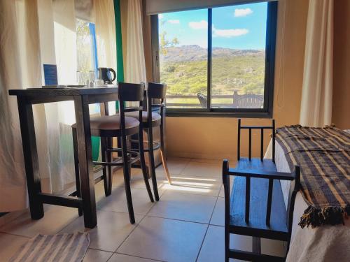 a room with a table and chairs and a window at Los Ancares Resort in Mina Clavero