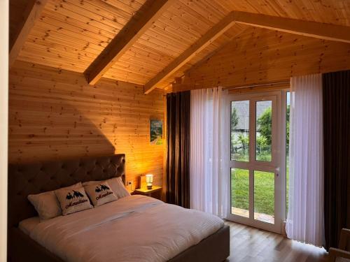 a bedroom with a bed with a wooden wall at Thethi Mountain Villas in Theth