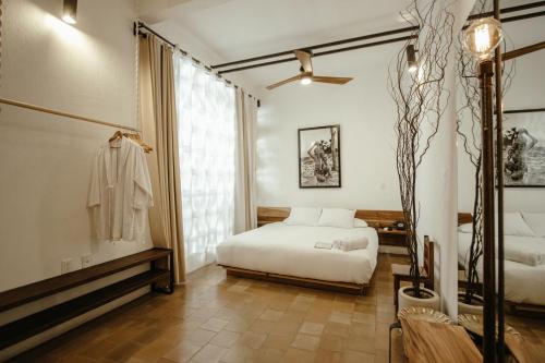 a bedroom with a white bed and a window at Hotel Sin Nombre in Oaxaca City