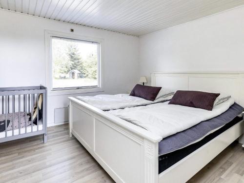 un lit blanc dans une chambre avec une fenêtre dans l'établissement 8 person holiday home in Storvorde, à Storvorde