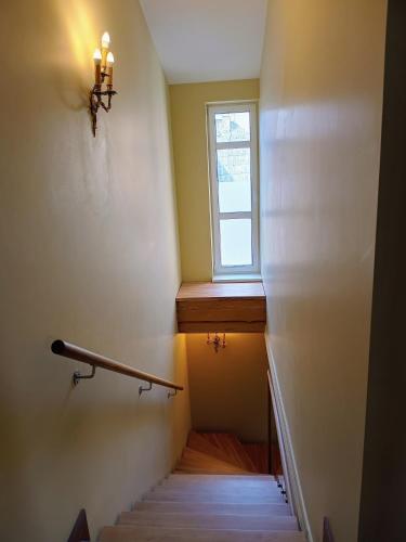 a stairway with a window and a stair case at Ernests' unique townhouse with sauna, hot tub and free parking in Rīga