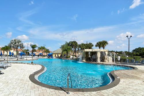 a swimming pool at a resort with blue water at Trendy Retreat - Great Location - Fully Loaded in Kissimmee