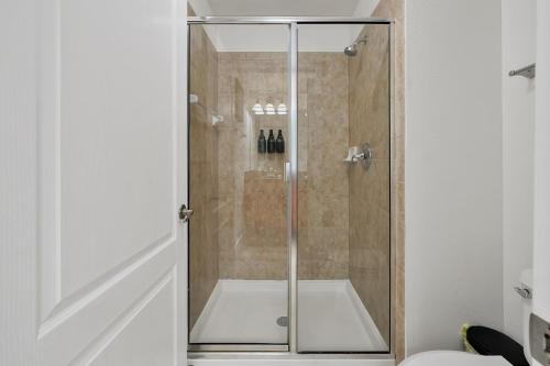a shower with a glass door in a bathroom at Trendy Retreat - Great Location - Fully Loaded in Kissimmee