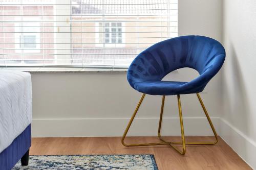 a blue chair sitting in front of a window at Trendy Retreat - Great Location - Fully Loaded in Kissimmee