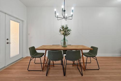 a dining room table with chairs and a vase with flowers at Trendy Retreat - Great Location - Fully Loaded in Kissimmee