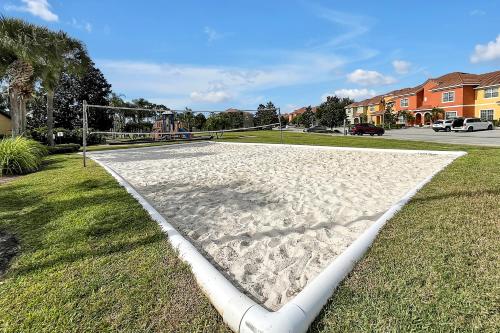 a volleyball court with a net on the grass at Trendy Retreat - Great Location - Fully Loaded in Kissimmee