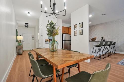 a kitchen and dining room with a wooden table and chairs at Trendy Retreat - Great Location - Fully Loaded in Kissimmee