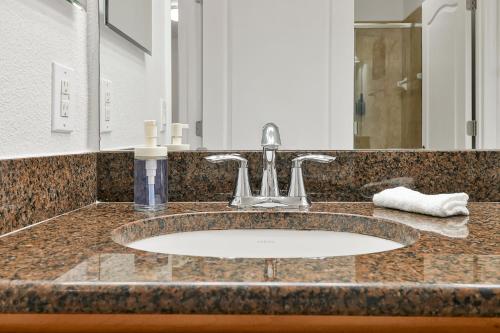 a bathroom counter with a sink and a mirror at Trendy Retreat - Great Location - Fully Loaded in Kissimmee