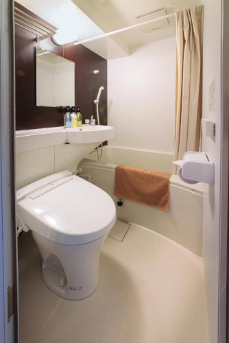 a bathroom with a white toilet and a sink at Kyoto Travellers Inn in Kyoto