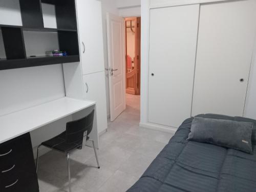 1 dormitorio con escritorio y 1 cama. en Departamento Verbenas Céntrico con cochera, en Santa Rosa