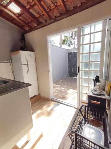 a kitchen with a refrigerator and an open door at Casa de Dois Quartos in Boituva