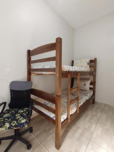 Zimmer mit 2 Etagenbetten und einem Stuhl in der Unterkunft Casa de Dois Quartos in Boituva