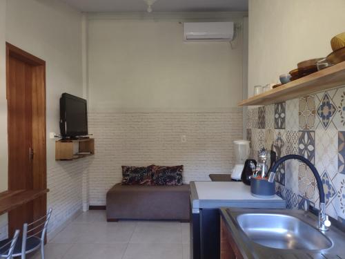 cocina con sofá y TV en una habitación en Casas Porto Belo, recanto em meio a natureza e próximo a praia, en Porto Belo