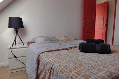 - une chambre avec un lit et une porte rouge dans l'établissement n2 jolie F2 emplacement idéal, à Hérouville-Saint-Clair