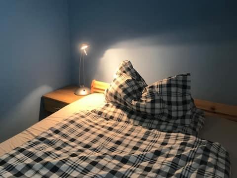 een bed met kussens in een kamer bij Large double room next to Elisabeth Line in Abbey Wood