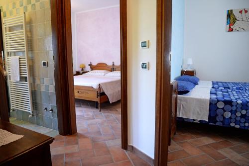 a bedroom with a bed and a bathroom with a mirror at Casa Vittoria in Piano Delle Pieve