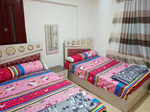 a bedroom with two beds and a mirror at مرسي مطروح in New cairo