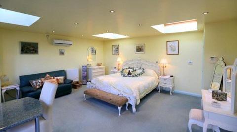 コルチェスターにあるPheasant Suitesの広いベッドルーム(ベッド1台、ソファ付)