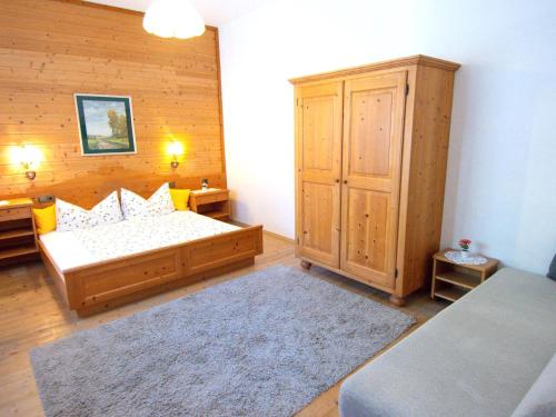 ein Schlafzimmer mit einem Bett und einer Holzwand in der Unterkunft Kirschbaum 1 in Ehrwald