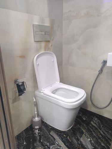 a white toilet in a bathroom with a shower at studio apartment for you in Birkirkara
