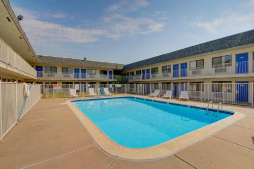a swimming pool in front of a building with a hotel at Motel 6-Wichita, KS - AIRPORT in Wichita
