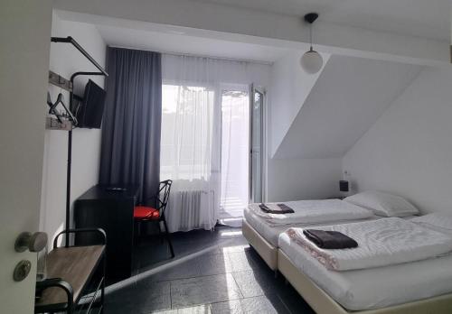 a bedroom with two beds and a desk and a window at Am Basler Tor in Grenzach-Wyhlen