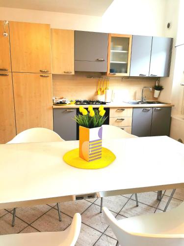a kitchen with a table with yellow flowers on it at Old Town Apartment with Terrace - Live Love Lake in Peschiera del Garda