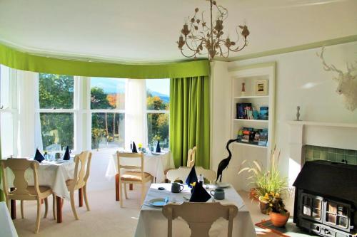 a living room with a table and chairs and a fireplace at Tirindrish House B&B in Spean Bridge