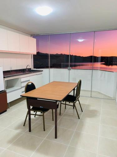 a kitchen with a wooden table and two chairs at Lagamar Hotel Varginha in Varginha