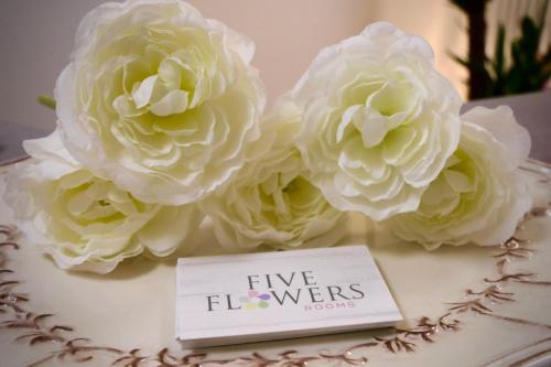 a cake with white flowers and a sign that says five flowers at Five Flowers Guest House - self check-in in Trieste