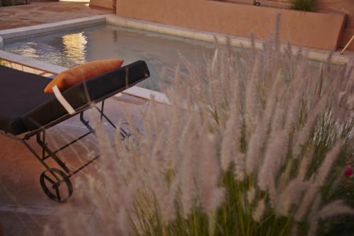 une chaise en face d'une piscine d'eau dans l'établissement Riad Caravane, à Aït Ben Haddou