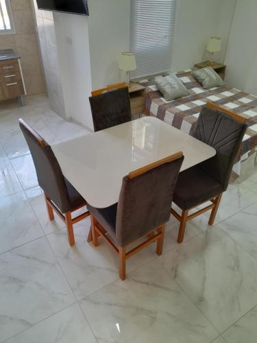a white table and chairs in a room with a bed at Tres Fronteras Apart 4 in Puerto Iguazú