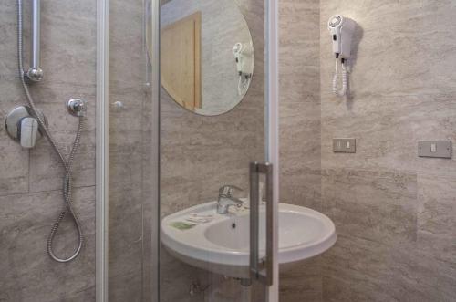 a bathroom with a sink and a shower with a mirror at Hotel Casa Alpina - Alpin Haus in Selva di Val Gardena