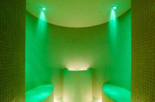 a green bathroom with two toilets with green lights at Medjugorje Hotel & Spa in Međugorje