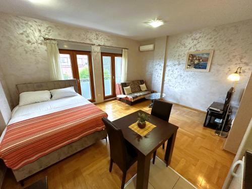um quarto com uma cama e uma mesa num quarto em Renta Stanovi Podgorica em Podgorica