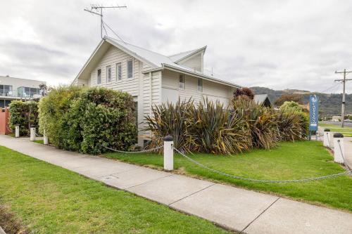 a white house with a hose in a yard at Captain's at the Bay in Apollo Bay