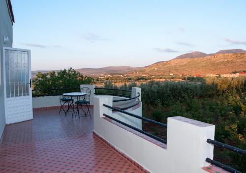 a balcony of a house with a table and chairs at Vila Haja - Beautiful Farmhouse with a Private Pool! in Imouzzer Kandar