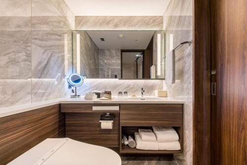 a bathroom with a sink and a toilet and a mirror at Hyatt Regency Tokyo Bay in Urayasu