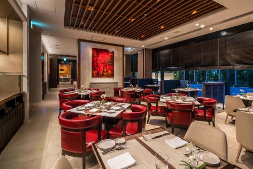 a restaurant with red chairs and tables in a room at Hyatt Regency Tokyo Bay in Urayasu