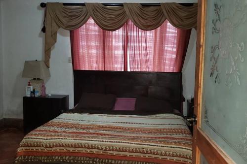 a bed in a room with a window with a bed sidx sidx sidx at Casa Bonilla El Tirol Heredia CR in Alto del Roble