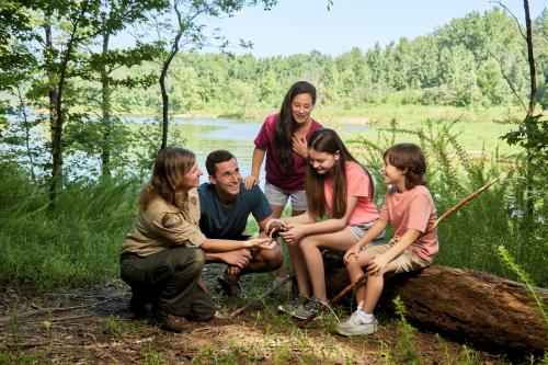 a group of people sitting on a log near a river at Barren River Lake State Resort Park in Lucas