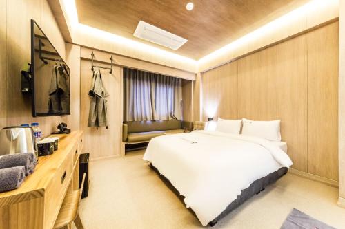 a hotel room with a large bed and a television at Sangju Hotel Seoul in Seoul
