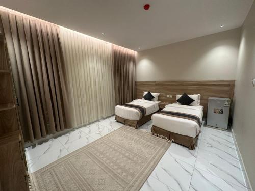 Habitación de hotel con 2 camas y alfombra en انوار البركة للوحدات السكنية en Medina
