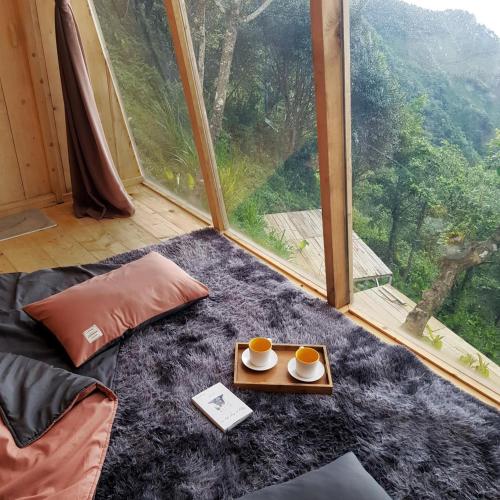 a room with a bed and a tray with cups of coffee at Tà Xùa Haus Meej Homestay in Bắc Yên
