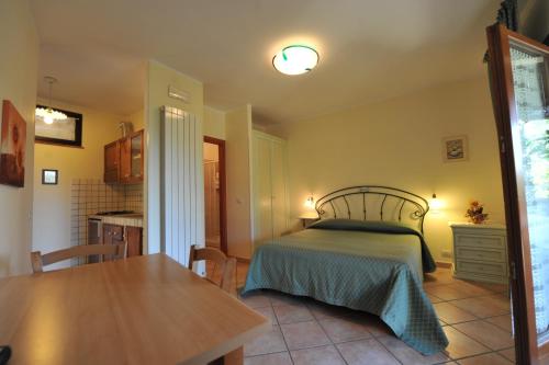a bedroom with a bed and a table and a kitchen at Casa Vacanze Patrizia in Montefiore dellʼAso
